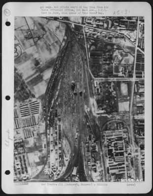 Budapest, Hungary. First bomb bursts in the center of rolling stock at a freight terminal record a bulls-eye for Army Air forces bombers in their initial attack on the Hungarian capital of Budapest. Adjacent oil refineries and the Tokol airdrome also
