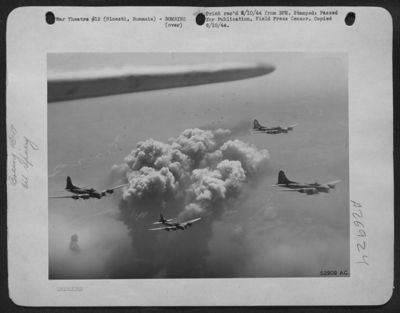 A pillar of smoke reaches the height of these Boeing B-17 Flying Fortresses of MAAF after they had dropped their bombs on the oil refineries at Ploesti, Rumania on 28 July 44. Numerous flak bursts can be seen in the back ground, as the enemy