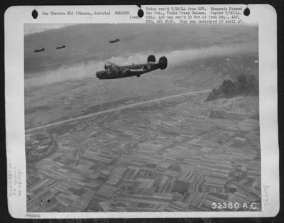 A column of black smoke rises from the target area, the Florisdorf Railyards and oil storage facilities near Vienna, Austria, on 8 July 1944, as heavy bombers of the 15th Air force laid a neat pattern of bombs, scoring hits on the west portion of the